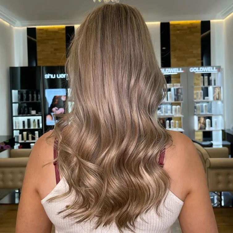 Lange aschblonde Wellen mit Strähnen, von hinten