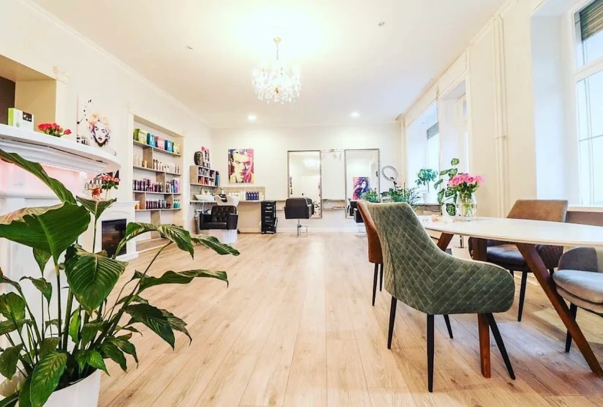 Der helle Salon mit Stuck, Kronleuchter, großen Spiegeln und Pop-Art an den Wänden